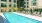 The pool area at our apartments in Arlington, featuring reclining chairs, umbrellas, and a view of the apartments.