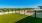 Rooftop dog park at our apartments Arlington, featuring a fenced in astro turf field and a view of the city.