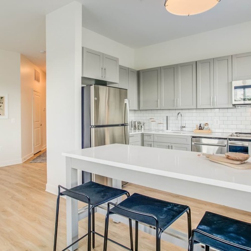 Model kitchen at our apartments in Arlington, VA, featuring white countertops and stainless steel appliances.